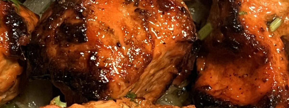 Tandoori chicken pieces glazed deep orange, served with a wedge of lime.